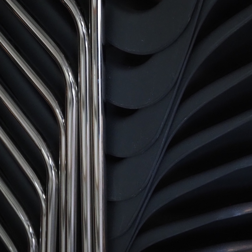 Stackable chair with anthracite polypropylene shell and tubular steel legs