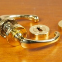 Door handle in brass plated aluminium with key rosettes by Linea Bertomani