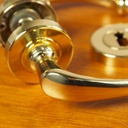 Door handle in brass plated aluminium with key rosettes by Linea Bertomani