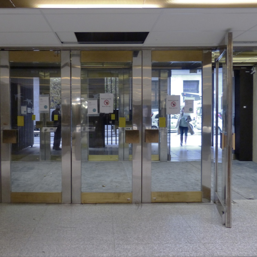 Glass door in stainless steel and bronze from the main entrance of the Générale de Banque(H. 235,5 x 108 cm)